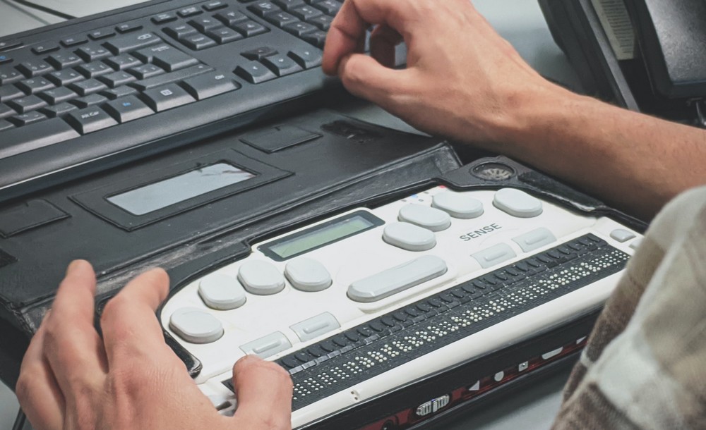 Blind man using a braille screen reader